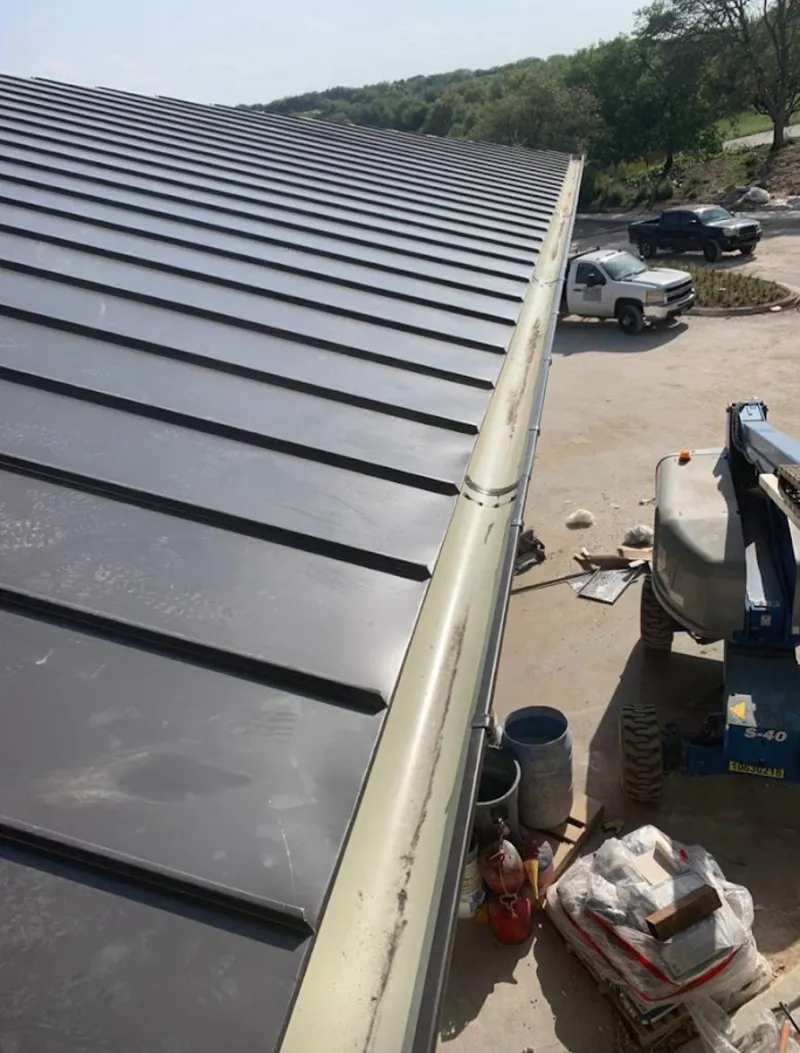 Standing seam panel and gutter detail on a metal roofing jobsite in Glens Falls